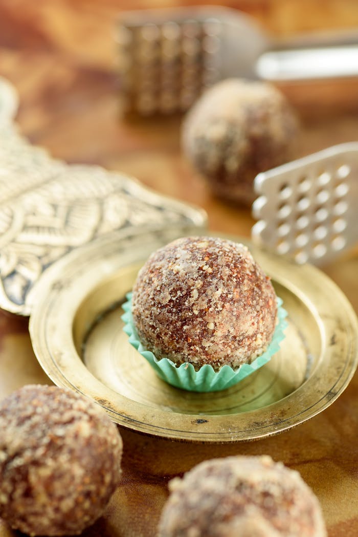Crafting Captivating Headlines: Your awesome post title goes here Close-up of a delicious laddoo on a brass plate, showcasing intricate food styling.